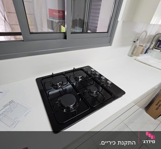 כיריים גז שחורות על משטח עבודה לבן